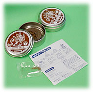 Photo of two Bumpy Trot tins with illustrated lids beside a printed leaflet on a green background.